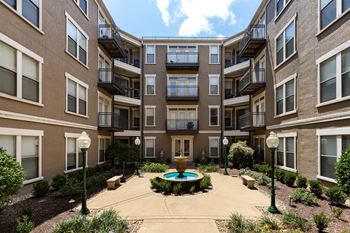 a courtyard with a fountain and seating area at the bradley braddock road station apartments